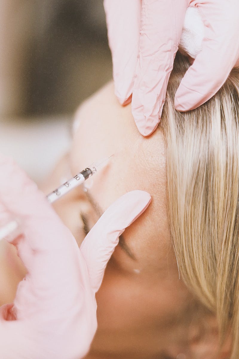 Close-up of a cosmetic injection procedure enhancing facial features in a clinic setting.