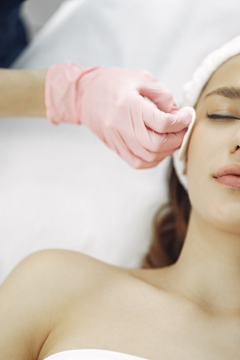 Woman enjoying a soothing facial treatment in a serene spa setting, promoting relaxation and beauty.