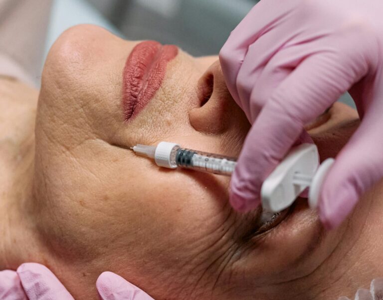 Close-up of a beautician administering a Botox injection to a woman at a clinic.